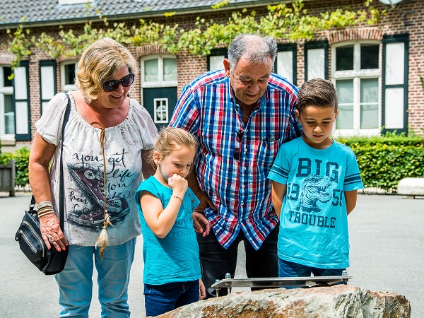 Gezin kijkt naar het verhaal van een luisterplek van de Liberation Route Europe