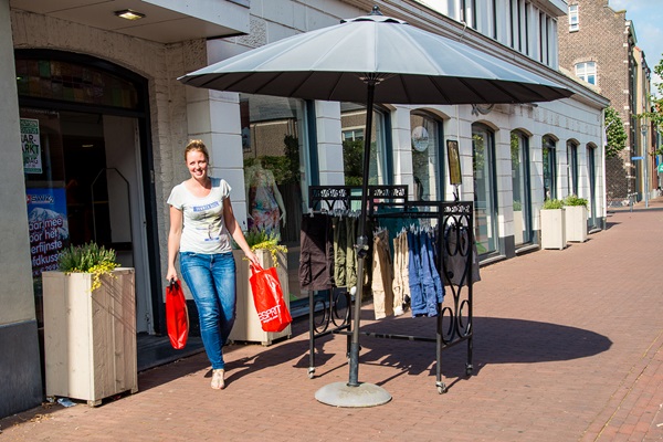 Vrouw komt uit de winkel met twee winkeltassen